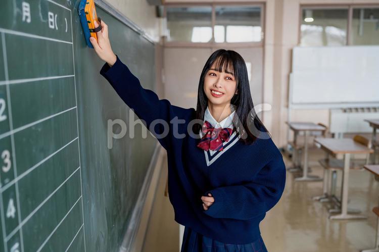 黒板を消しながら笑う受験生 女性,女子高,高校生の写真素材