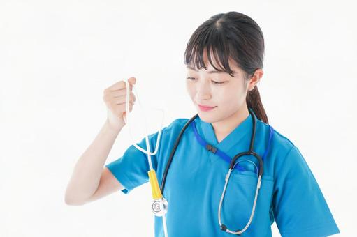 点滴を使う笑顔の若いナース 仕事着,白衣,白バックの写真素材