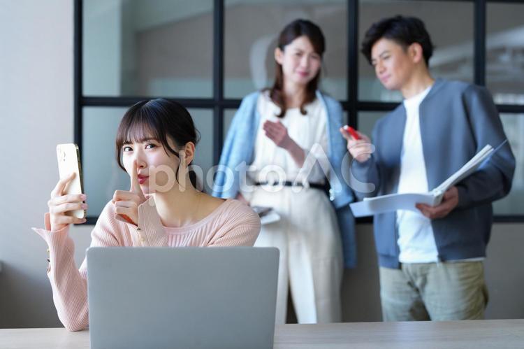 スマホを持ちポーズをする女性 女性,スマートフォン,内緒の写真素材