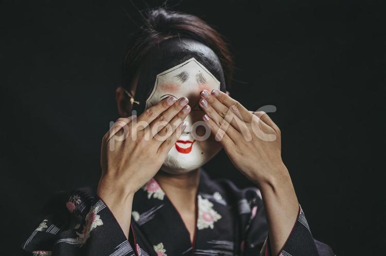 泣く仕草をするおかめ女性 おかめ,泣き笑い,お面の写真素材