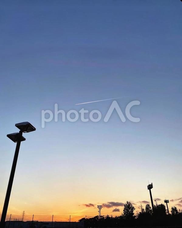 夕暮れ、飛行機雲 オレンジ色,トワイライト,外灯の写真素材