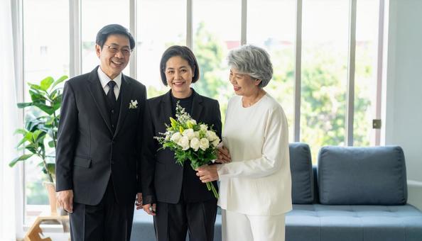 棺に花束を供えるミドルの男女 棺に花束を供えるミドルの男女の写真