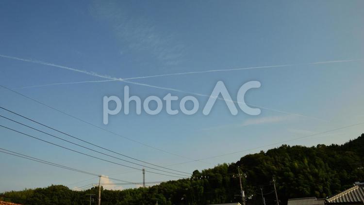 あわやニアミス・・？　クロスする飛行機雲 コピースペース,コントラスト,ジェット機の写真素材