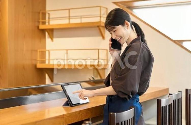 タブレットで管理をする飲食店の従業員 タブレット,従業員,女性の写真素材