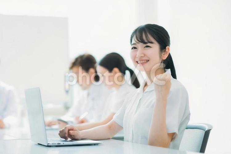白衣・ナース服を着た女性（ガッツポーズ） 看護師,ナース,介護士の写真素材