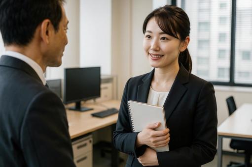 上司と話す女性社員の写真