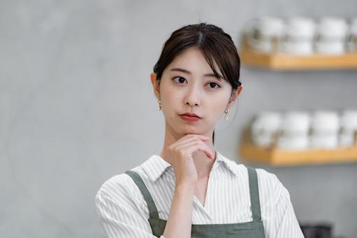 考えるエプロンをつけたスタッフ 考えるエプロンをつけたスタッフ カフェ,店員,笑顔の写真素材