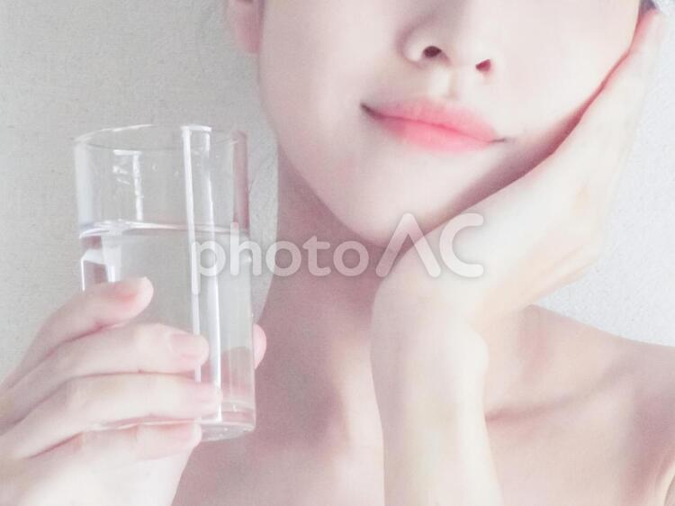 水を飲みながら頰を撫でる女性 水,飲む,女性の写真素材