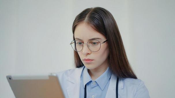 カルテを見ている聴診器を身につけた眼鏡の女性 医療,予防,保険の写真素材