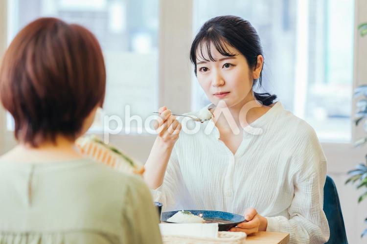 カフェで食事しながら困る女性 女友達,ママ友,友達の写真素材