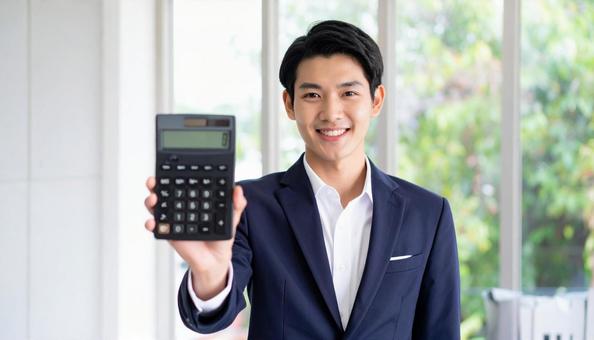 訪問営業をして電卓を示す若い男性 訪問営業をして電卓を示す若い男性の写真