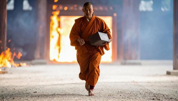 焼け落ちる寺から秘仏を抱え出てくる僧侶 焼け落ちる寺から秘仏を抱え出てくる僧侶の写真