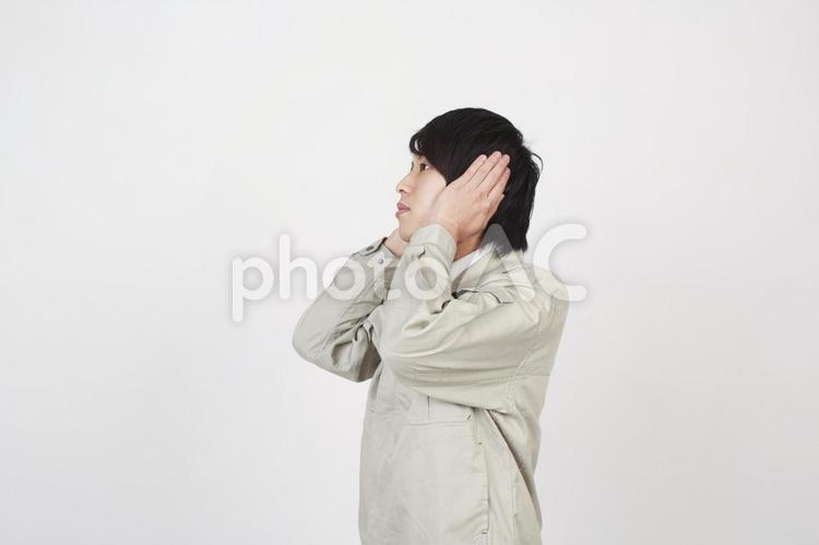 耳を塞ぐ作業着の男性1 男性,日本人,エンジニアの写真素材