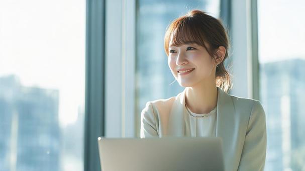 ノートパソコンを使用する女性会社員 ノートパソコンを使用する女性会社員の写真
