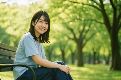 木陰のベンチでリラックスする女性の写真