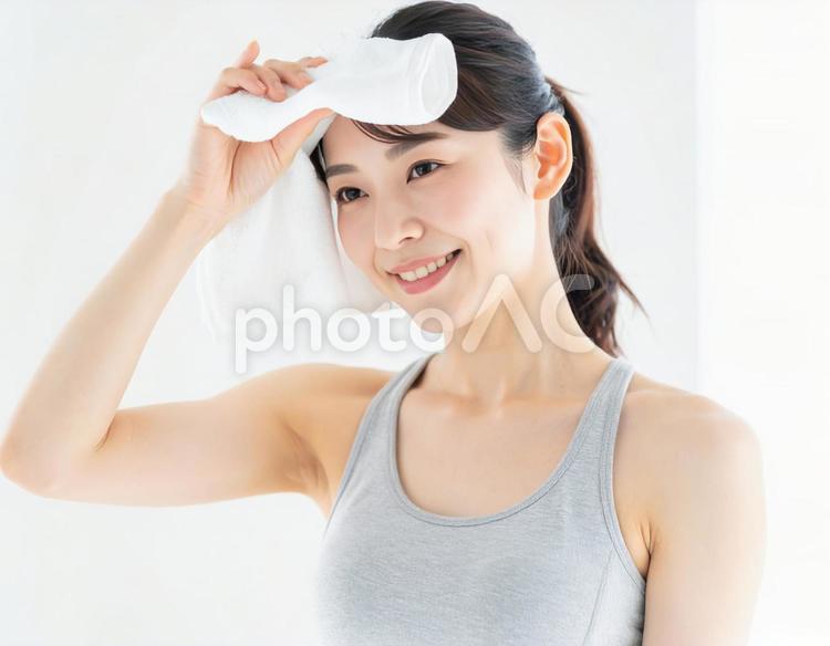 トレーニング後の汗を拭く笑顔の女性 女性,フィットネス,運動後の写真素材