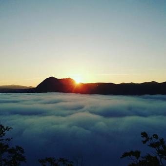 雲海に昇る日の出と山並みのシルエット 雲海に昇る日の出と山並みのシルエットの写真
