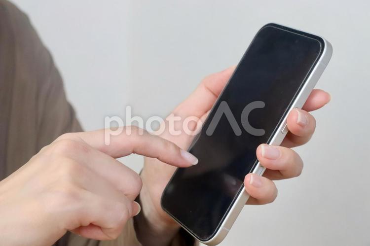 スマホを指さす女性 スマホ,女性,顔なしの写真素材