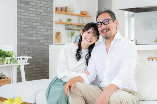 リビングでくつろぐミドルの夫婦 リビングでくつろぐミドルの夫婦 夫婦,家族,ミドルの写真素材
