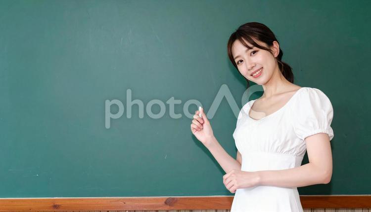 黒板に書こうとする先生 女性,ポーズ,教室の写真素材