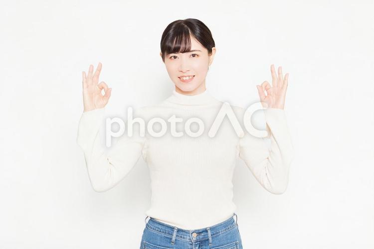 白い背景の前に立ってOKのジェスチャーをする女性 ok,yes,はいの写真素材