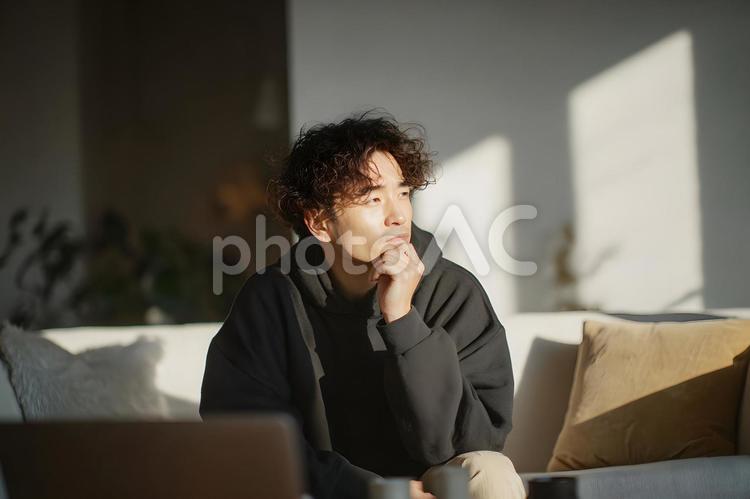 自宅で思索にふける若いアジア人男性 若いアジア人男性,思索,考えるの写真素材