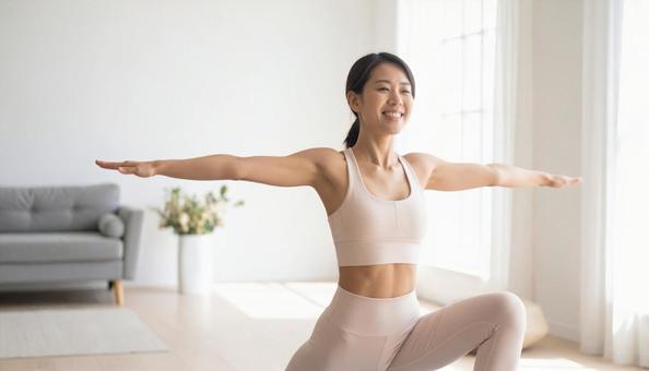 明るい部屋でヨガを楽しむ笑顔の女性の写真