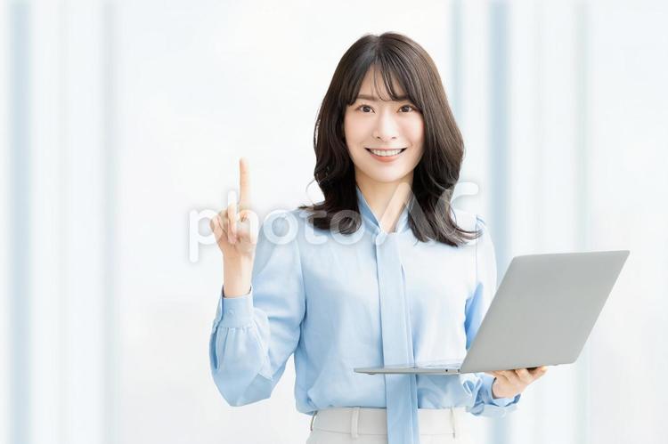 パソコンを持って案内をする笑顔の女性 女性,指,案内の写真素材