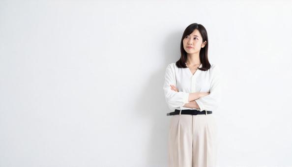 腕を組んで考える若い女性のポートレートの写真