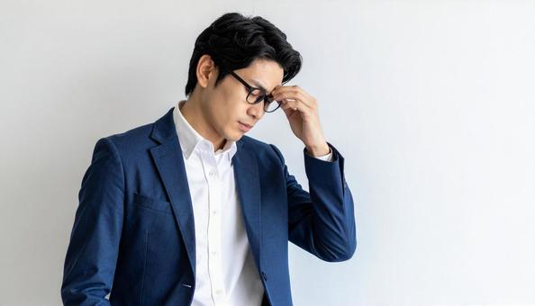ビジネスイメージ うつむき悩む日本人男性 ビジネスイメージ うつむき悩む日本人男性の写真