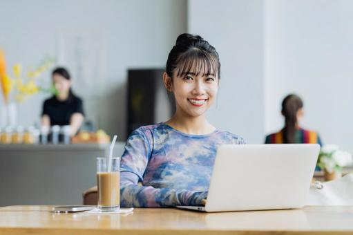 カフェで仕事をするフリーランスの若い女性 カフェで仕事をするフリーランスの若い女性の写真