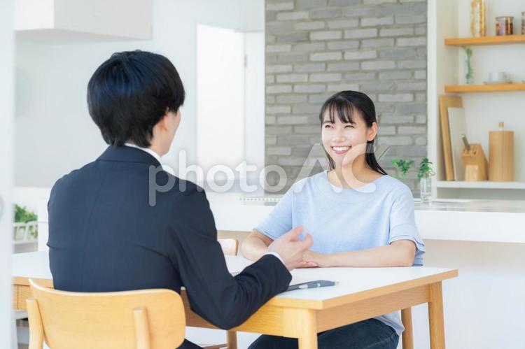 リビングで女性と商談をするビジネスマン 営業,金融,保険の写真素材