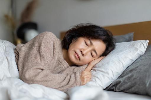 枕に顔を埋めて休息する人の写真