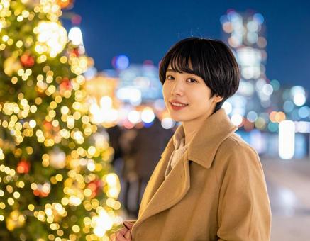 クリスマスツリーとキャメルコートの彼女の写真