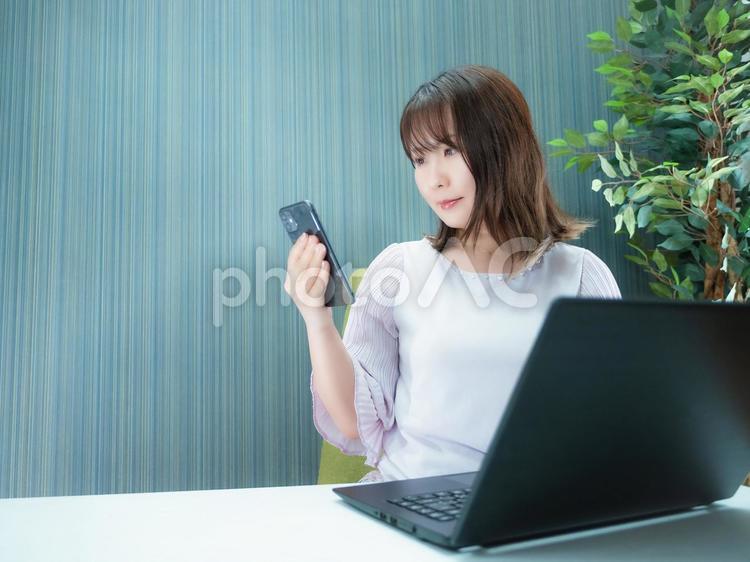 02：スマホを操作する女性 ノートpc,ラップトップ,pcの写真素材