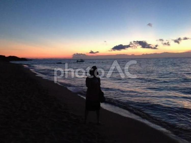 海と女性のシルエット 海,風景,夕日の写真素材