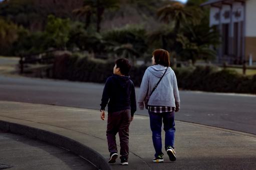 ＜人物＞海辺（堤防沿い）を散歩する親子 女性,子供,男性の写真素材