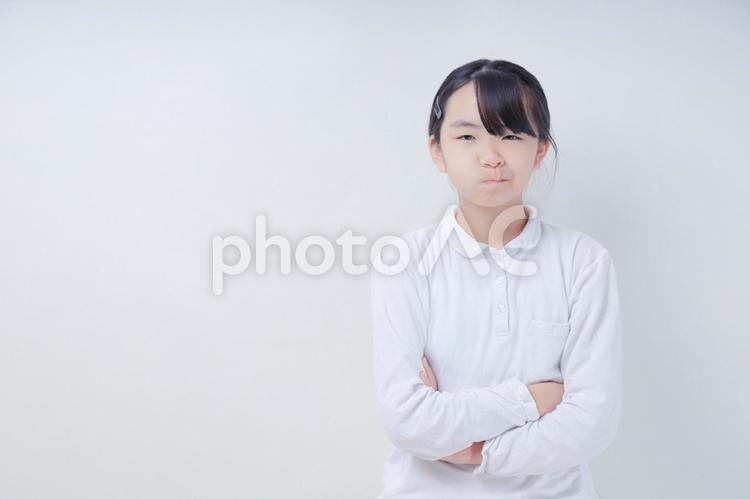 腕組みをした顰めっ面の女の子 女性,日本人,若いの写真素材