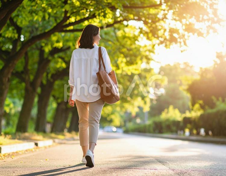 自然を感じながら歩く女性の後ろ姿 通勤,歩く,後ろ姿の写真素材