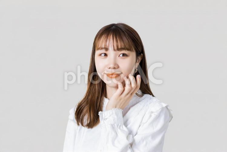 頬に手を当てる笑顔の女性 女性,人物,若いの写真素材