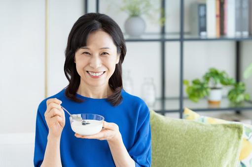 ヨーグルトを食べるミドルの女性 ヨーグルトを食べるミドルの女性の写真