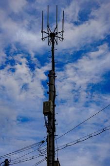 青空にそびえる携帯電話の基地局のアンテナ アンテナ,基地局,電柱の写真素材