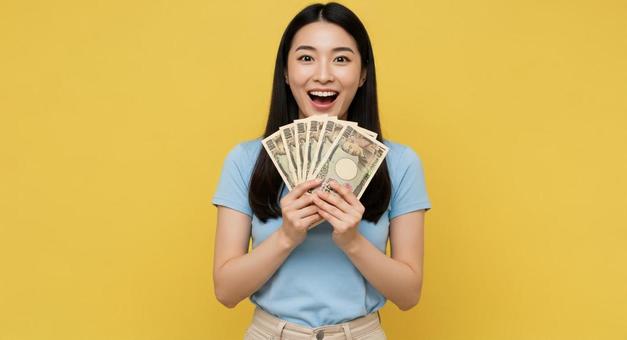 お札を手にして喜ぶ女性 お札を手にして喜ぶ女性の写真