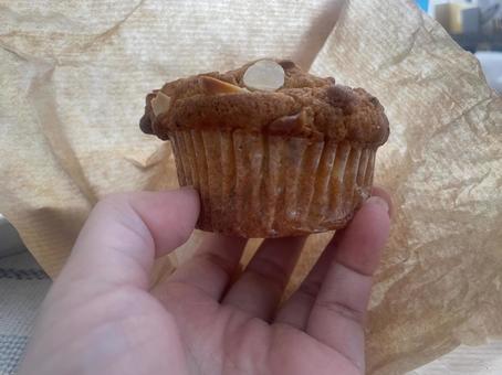 マフィンを持つ手元のクローズアップ マフィン,アーモンド,スライスアーモンドの写真素材