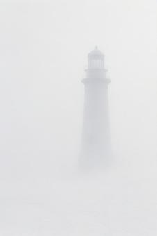霧に溶ける灯台の写真