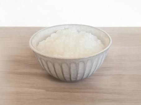 木のテーブルに置いたお粥を盛った茶碗 木のテーブルに置いたお粥を盛った茶碗の写真