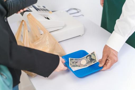 レジスターで現金支払い・会計する店員 レジスターで現金支払い・会計する店員 現金,現金支払い,現金取引の写真素材