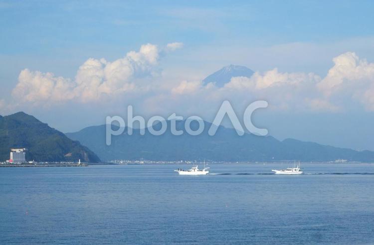 もうすぐ雲で隠れそうな富士山の下を通る船 富士山,船,海の写真素材