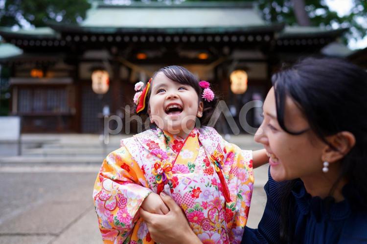花飾りをつけた女の子を見つめる母の笑顔 七五三,お参り,七五三参りの写真素材