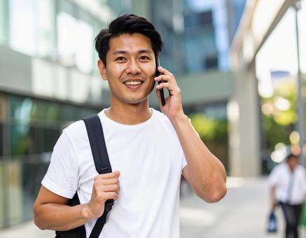 街中で電話をかける男性 街中で電話をかける男性の写真